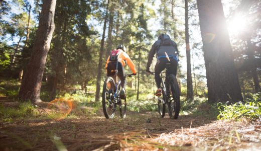 Biker couple riding mountain bike in the forest at countryside